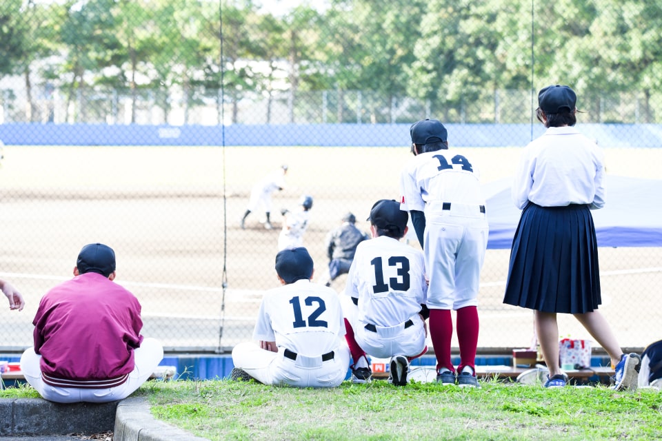 試合の様子を眺める少年野球の選手たち